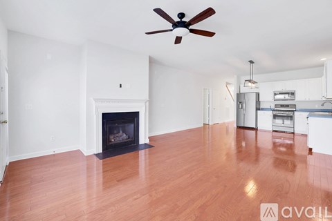 A living room with a fireplace and a ceiling fan.