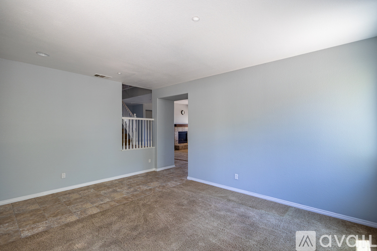 A spacious room with a carpeted floor and a window with bars.