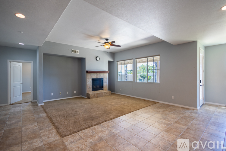 A living room with a fireplace and a ceiling fan.