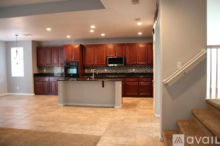 A kitchen with brown cabinets and a black countertop.