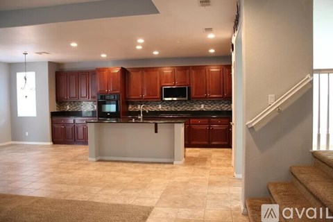 A kitchen with brown cabinets and a black countertop.