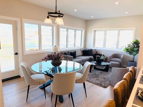 A modern dining room with a glass table and chairs.