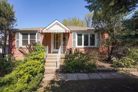 A red brick house with a white door and windows.