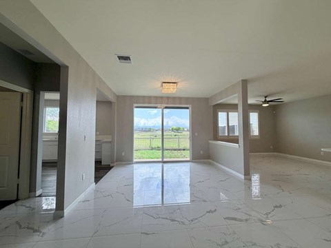 A spacious room with marble flooring and a ceiling fan.