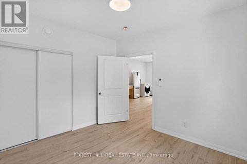 A white room with a sliding door and a brokerage sign.