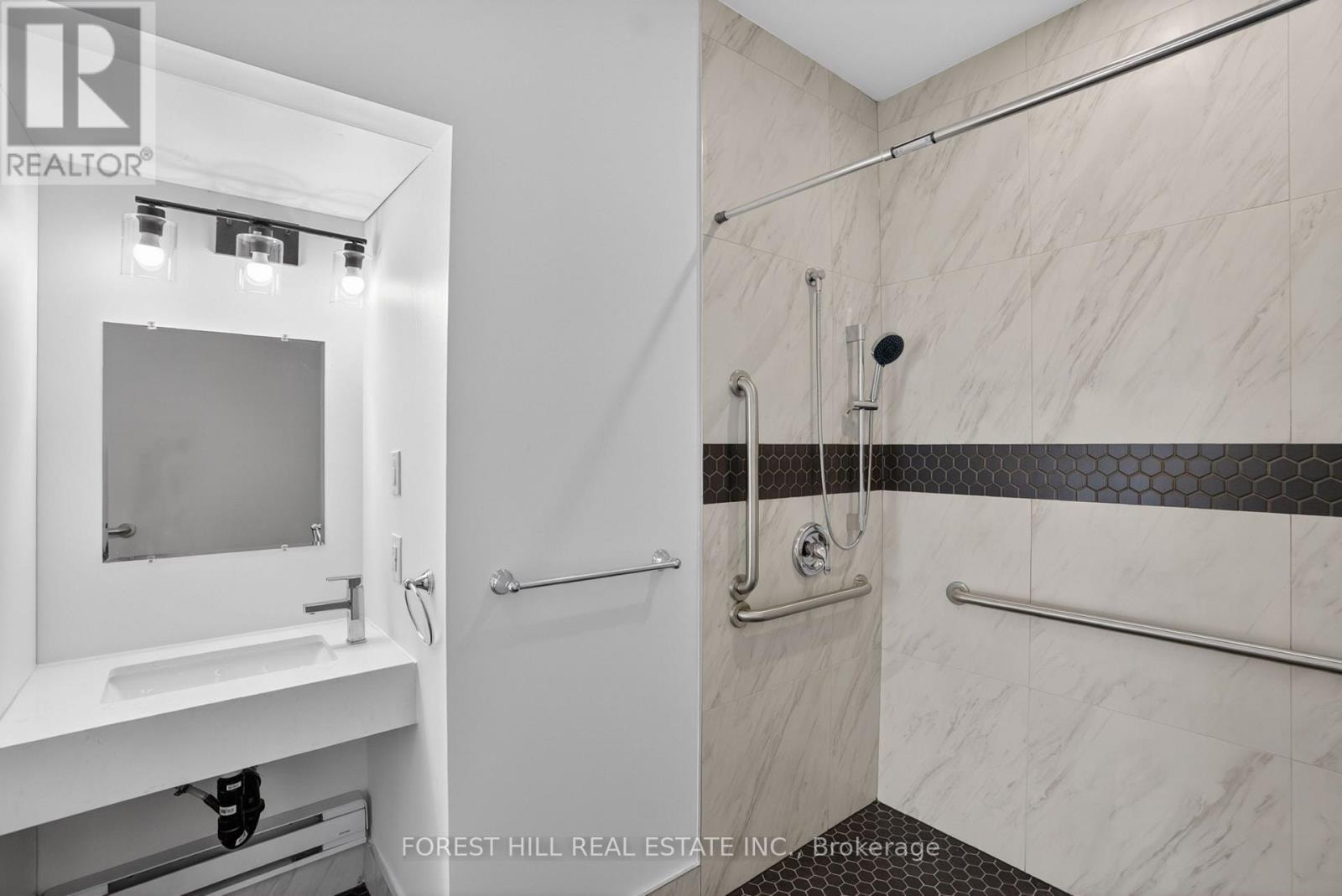 A bathroom with a walk in shower and a vanity.