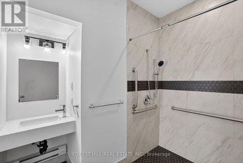 A bathroom with a walk in shower and a vanity.