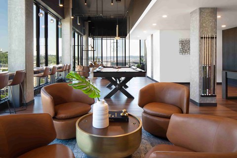 A room with brown leather chairs and a table with a plant on it.