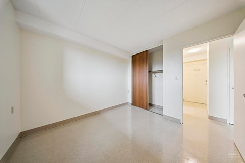 A long hallway with a brown door in the middle.