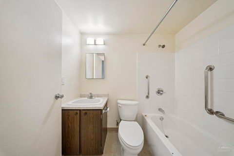A white bathroom with a toilet, sink, and bathtub.
