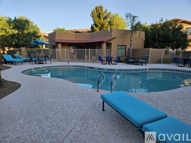 A pool with a bench and chairs around it.