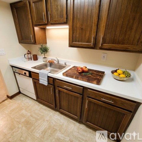 A kitchen with wooden cabinets and a white countertop.