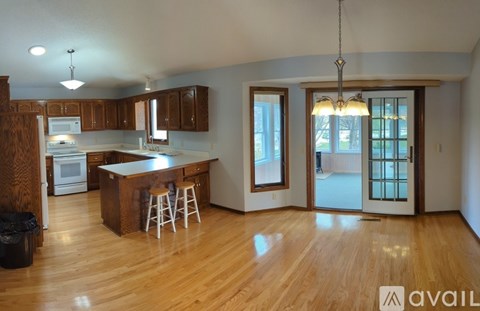 A kitchen with wooden floors and a bar area.