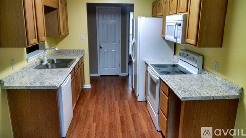 A kitchen with wooden cabinets and a granite countertop.