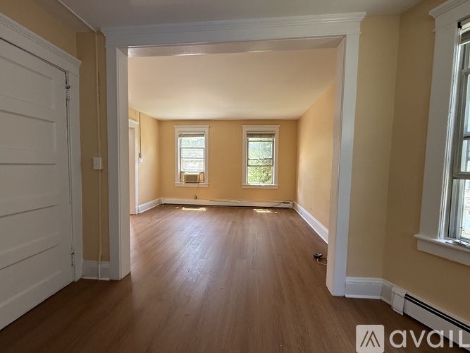 A room with wooden floors and two windows.