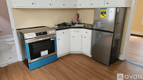 A kitchen with a blue oven and a stainless steel refrigerator.