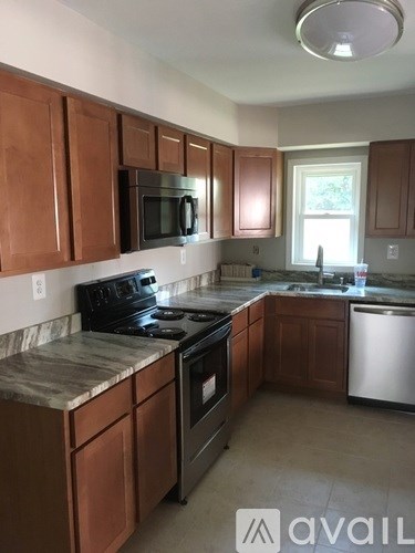 A kitchen with brown cabinets and a black stove top.