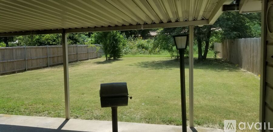 A backyard with a mailbox and a fence.