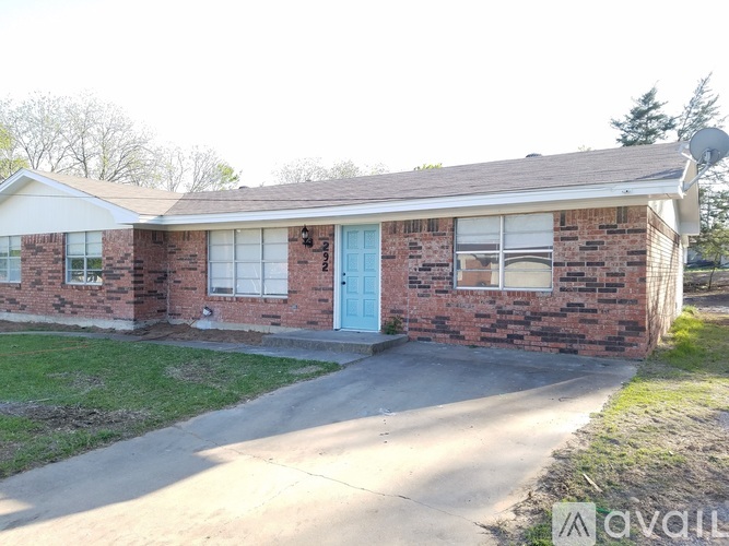 A brick house with a blue door and a satellite dish on the roof.