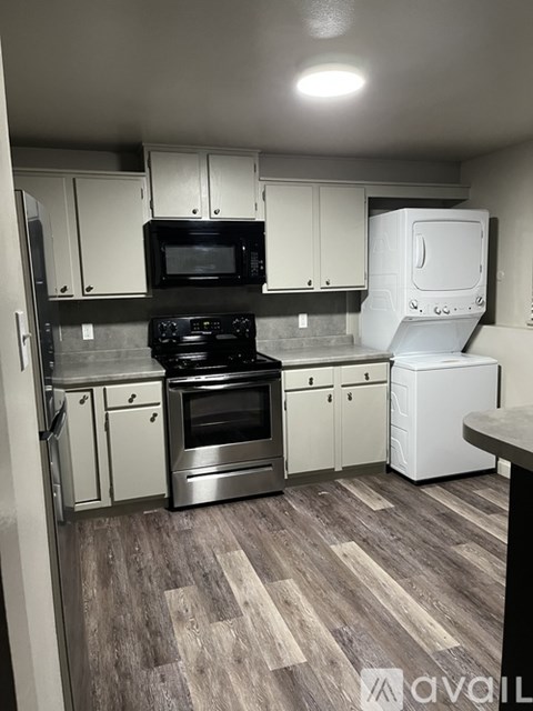A kitchen with a black microwave, stove, and oven.