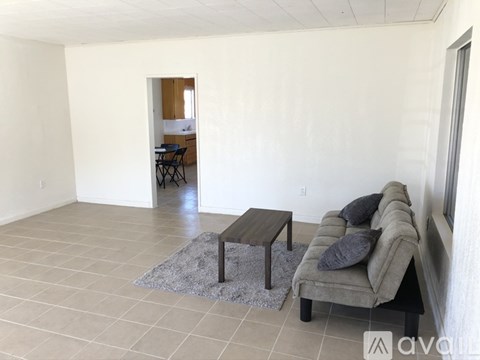 A living room with a couch, coffee table, and dining table.