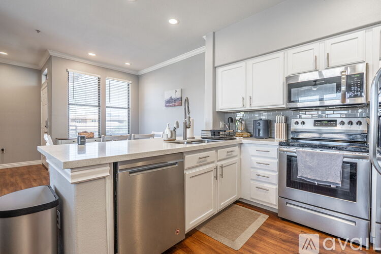A kitchen with white cabinets and stainless steel appliances.