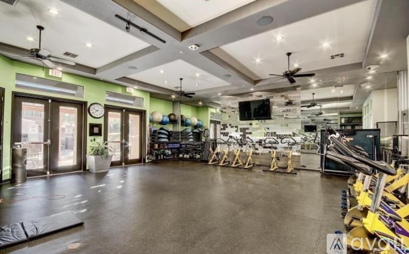 A spacious room with exercise equipment and mirrors on the wall.