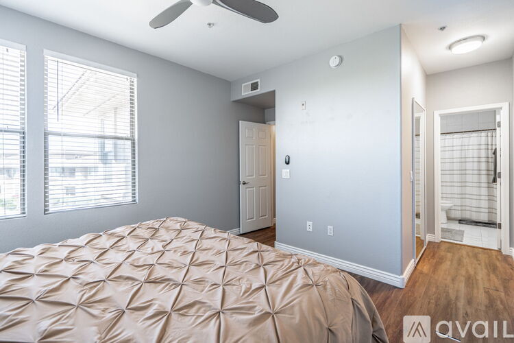 A bedroom with a bed, a ceiling fan, and a door.