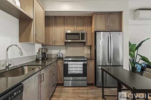 A kitchen with a stainless steel refrigerator and wooden cabinets.