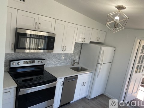 A kitchen with white cabinets and a black stove top oven.