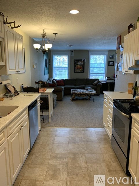 A kitchen with white cabinets and a black stove top oven.
