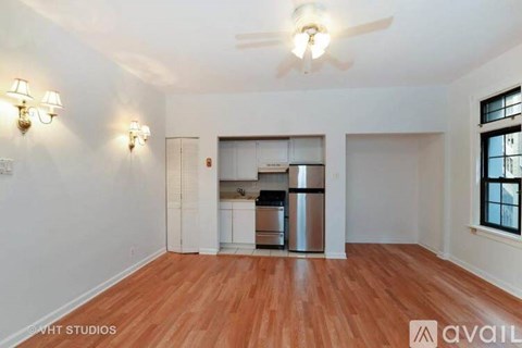 A kitchen with white cabinets and a stainless steel refrigerator is visible.