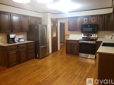 A kitchen with wooden cabinets and a black fridge.