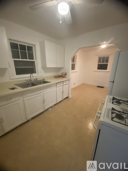 A kitchen with white cabinets and a stove top oven.