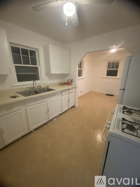 A kitchen with white cabinets and a stove top oven.