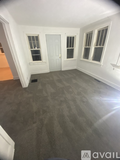 A room with a carpeted floor and white walls.