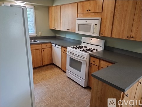 A kitchen with a white stove and refrigerator.