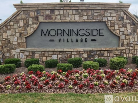 A sign that says Morningside Village in front of a stone wall.
