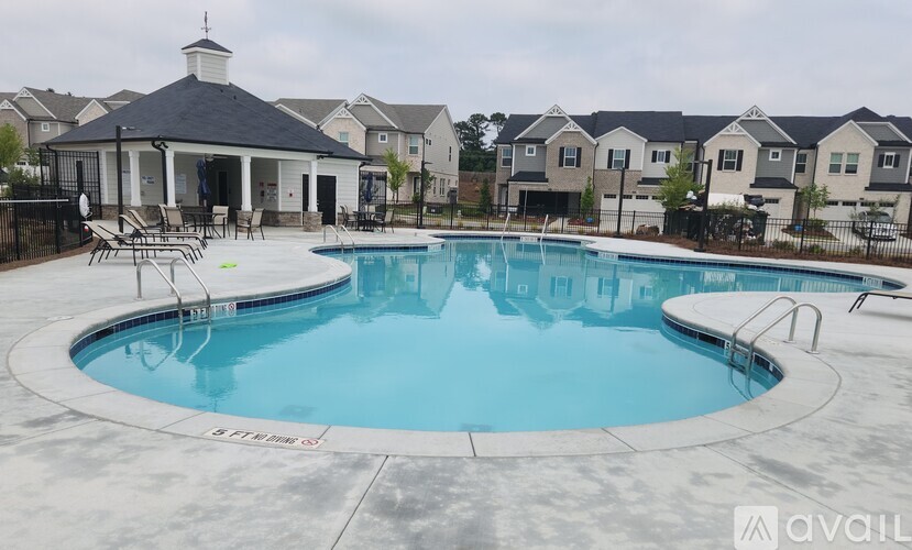 A pool with a pavilion in the background.