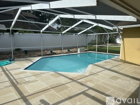 A pool under a white canopy with a hose on the ground.