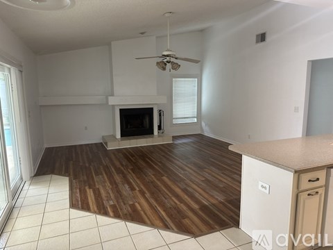 A living room with a fireplace and a ceiling fan.