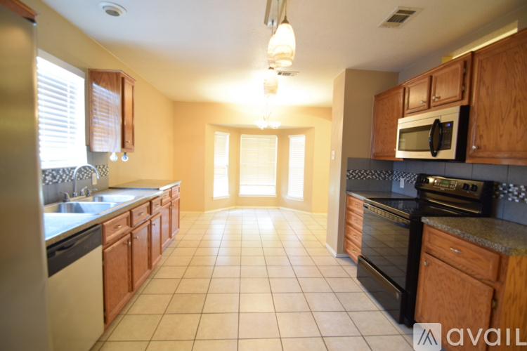 A kitchen with wooden cabinets and black appliances.