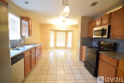 A kitchen with wooden cabinets and black appliances.