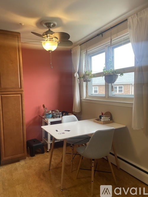 A room with a table and chairs and a ceiling fan.
