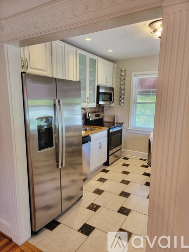 A kitchen with a checkered floor and a refrigerator.