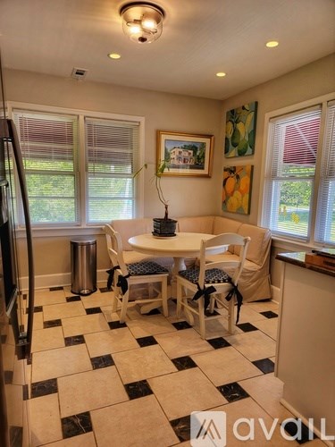 A kitchen with a checkered floor and a table with chairs.