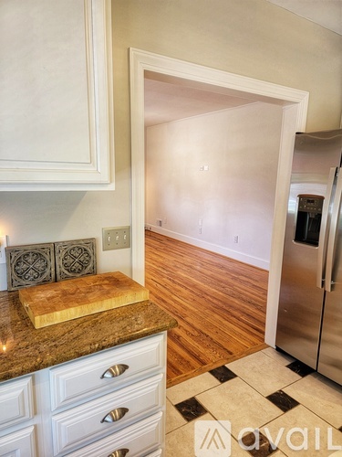A kitchen with a marble countertop and a refrigerator.