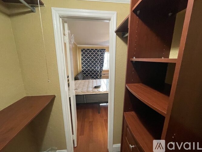 A small bedroom with a bed and a shelf.