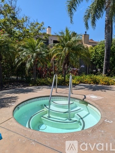 A hot tub in a garden with palm trees.