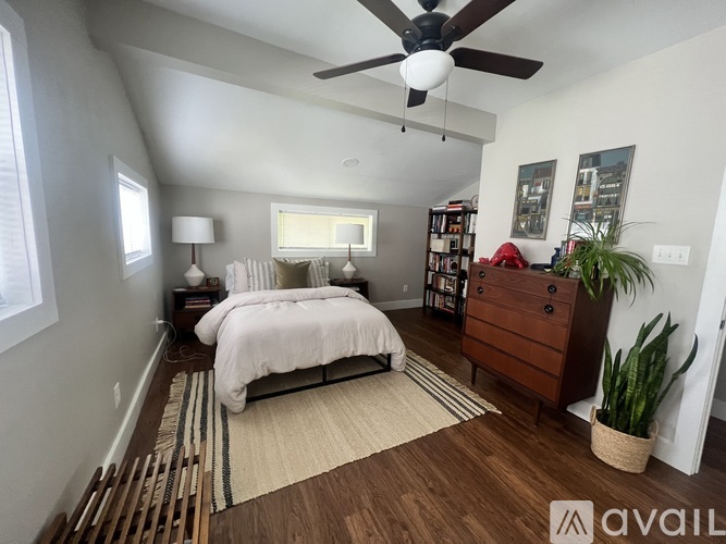 A bedroom with a bed, dresser, and ceiling fan.